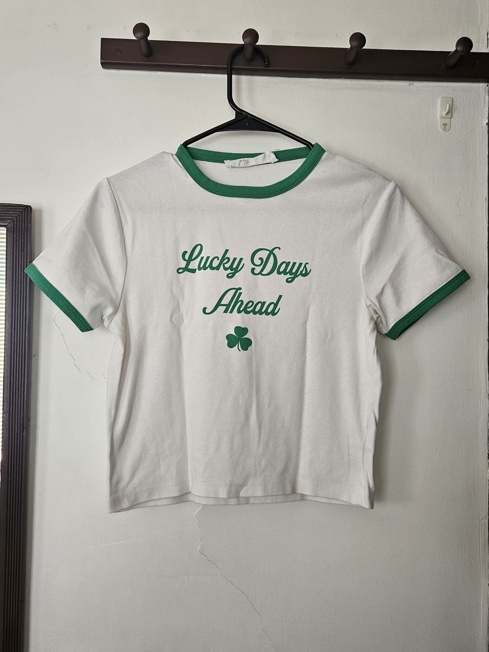 Primark White Tee with Green Trim and Clover Graphic.